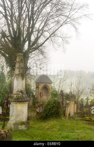 La nebbia che incombe su un cimitero medievale in Francia Foto Stock