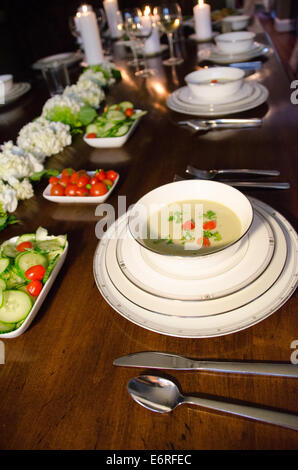 Impostazione tabella per una deliziosa cena al lume di candela con il partito e la zuppa di verdure su Nizza piatti cina