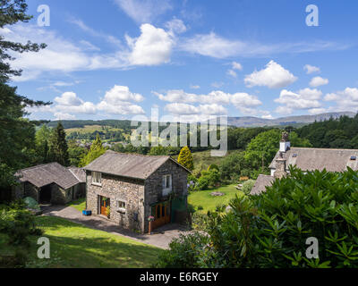 Costruire in pietra cottages guardando oltre fells in estate, nel distretto del lago, Inghilterra. Foto Stock