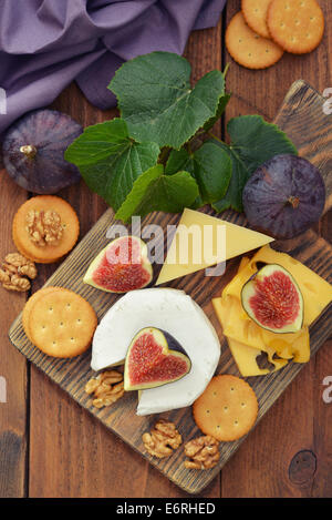 Formaggio Camembert con noci e fichi freschi su sfondo di legno Foto Stock