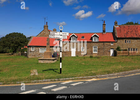 Goathland village green, segnaletica stradale e Memoriale di guerra, North Yorkshire, North York Moors National Park, Inghilterra, Regno Unito. Foto Stock