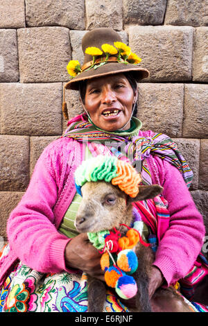 Il quechua donna in abiti tradizionali con un bambino llama - Cuzco, Perù Foto Stock