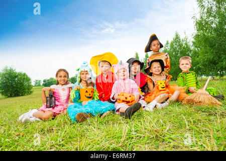 I bambini in costumi di Halloween sedersi insieme Foto Stock