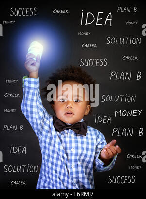 Ritratto di piccolo genio africano ragazzo con lampadina in mano sulla lavagna sfondo, torna a scuola, trovare il concetto di soluzione Foto Stock