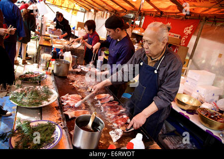 Pressione di stallo, negozio con cook, chef di cottura degli alimenti, pesce, calamari, totani, seppie. Il Parco Ueno, Tokyo, durante la fioritura dei ciliegi stagione Foto Stock