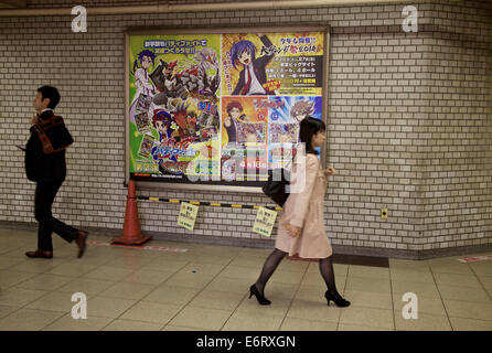 Persone, pendolari in stazione metropolitana e segno, poster, cartelloni pubblicitari con fumetti manga. Tokyo, Giappone, Asia Foto Stock