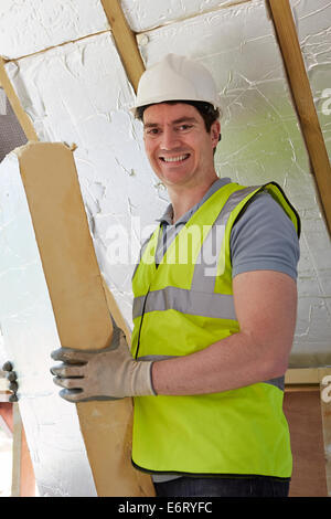Raccordo Builder tavole di isolamento nel tetto della nuova casa Foto Stock
