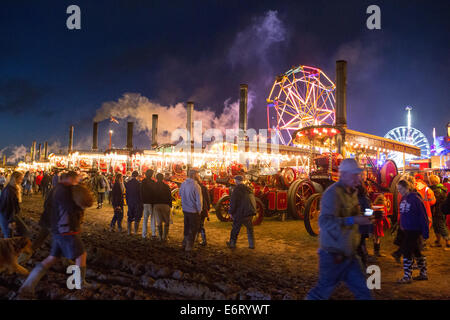 Tarrant Hinton, Dorset, Regno Unito. 28 Agosto, 2014. Il grande Dorset fiera del vapore, Tarrant Hinton, Dorset, Regno Unito. La linea di motori di trazione durante la notte con le luci della fiera in background Credito: Zach Williams/Alamy Live News Foto Stock