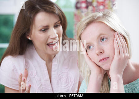 Madre sostenendo con figlia adolescente a casa Foto Stock