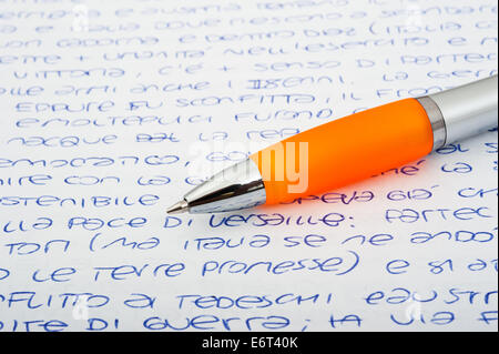 Penna a sfera arancione su sfondo lettere Foto Stock