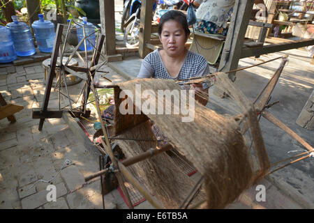 Luang Prabang, Laos - Marzo 1, 2014: donna lavoratrice in seta fabbrica di produzione a Luang Prabang, Laos. Foto Stock