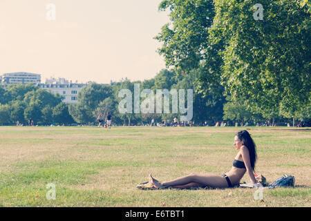 Una giovane donna a prendere il sole in Hyde Park Foto Stock