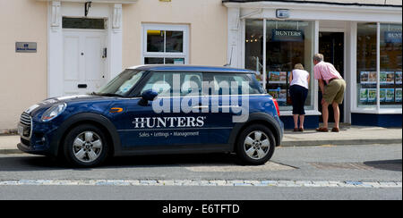 Uomo e donna che guarda nella finestra di cacciatori, agenti immobiliari, Easingwold, North Yorkshire, Inghilterra, Regno Unito Foto Stock