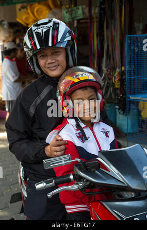 Yogyakarta, Java, Indonesia. Due giovani uomini con i caschi su una moto, il Mercato degli Uccelli. Foto Stock