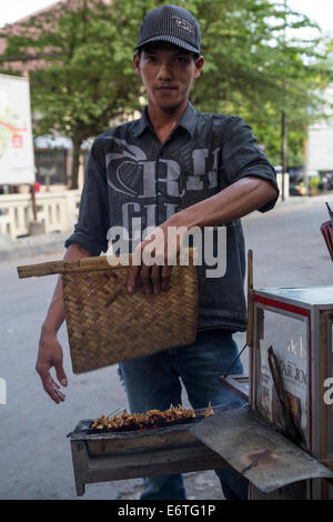 Yogyakarta, Java, Indonesia. Cucina di strada venditore la preparazione di spiedini di pollo o pollo Satay. Foto Stock