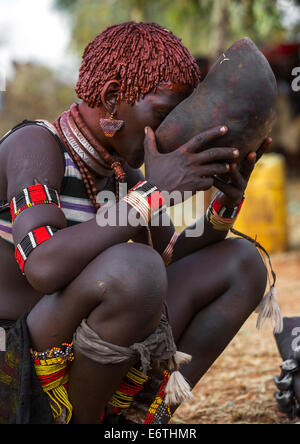 Tribù Bashada donna Drinkinf alcool durante un toro Jumping cerimonia, Dimeka, Valle dell'Omo, Etiopia Foto Stock