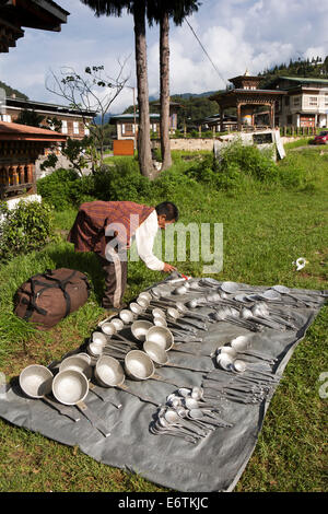 Il Bhutan orientale, Trashi Yangtse, Bazaar, trader visualizzazione utensili da cucina in metallo per la vendita Foto Stock