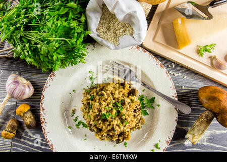 Italian risotto con funghi disposti su una tavola di legno Foto Stock