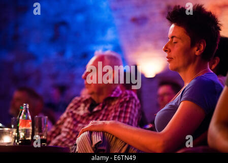 La donna nel pubblico godendo di concerto con gli occhi chiusi Foto Stock