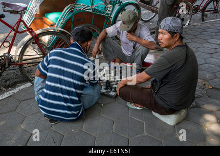 Yogyakarta, Java, Indonesia. Gli uomini che giocano a scacchi sul marciapiede. Foto Stock