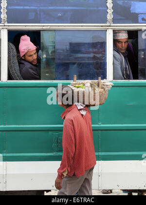 Venditore ambulante che vende spuntini per i passeggeri di autobus locali a Damak, Nepal Foto Stock