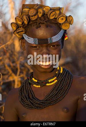 Ritratto di una giovane ragazza Dassanech indossando tappi di bottiglia copricapi e collane di perle, Omorate, Valle dell'Omo, Etiopia Foto Stock
