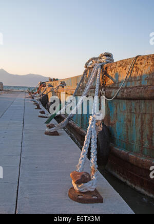 Vecchio sisal funi su un vecchio rustico e rusty cargo barca in porto. Foto Stock