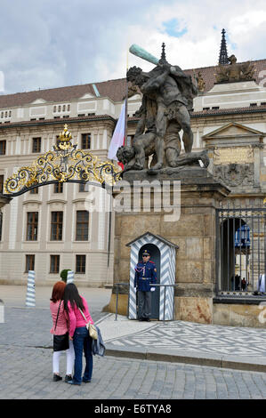 Due turisti scattano fotografie della guardia al di fuori del cancello del castello di Praga, Praga, Repubblica Ceca. Foto Stock