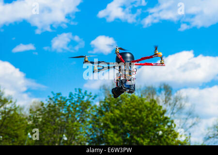 Vista ingrandita di un hexacopter con foto telecamera attaccata in volo a bassa quota Foto Stock