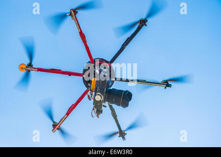 Vista ingrandita di un hexacopter con foto telecamera attaccata in volo Foto Stock