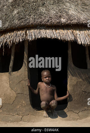 Tribù Nuer Little Boy all'ingresso della sua capanna, Gambela, Etiopia Foto Stock