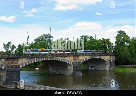 Un tradizionale tram elettrico attraversando uno dei ponti storici della città di Praga, Repubblica Ceca. Foto Stock
