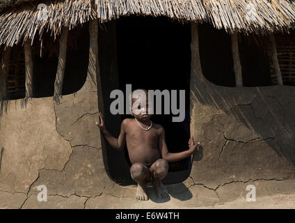 Tribù Nuer Little Boy all'ingresso della sua capanna, Gambela, Etiopia Foto Stock