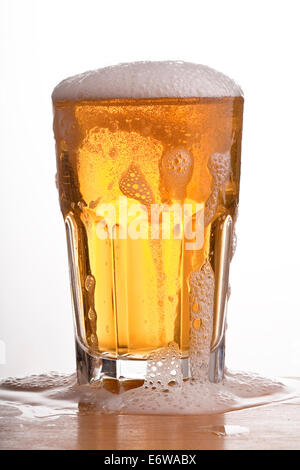 Bicchiere di birra traboccante. Foto Stock