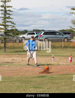 Calgary, Alberta, Canada. Il 30 agosto, 2014. L'uomo misura la lunghezza di tiro come martello colpisce la terra durante il martello evento di lancio a Calgary Giochi delle Highland, Calgary, Alberta, Canada sabato il 30 agosto 2014. La Calgary giochi sono una lunga tradizione, andando nel loro secondo secolo di quest'anno. Credito: Rosanne Tackaberry/Alamy Live News Foto Stock