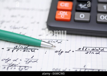 Equazioni closeup. Compiti a casa. Risolvere problemi matematici. Focus sulla penna. Profondità di campo. Foto Stock