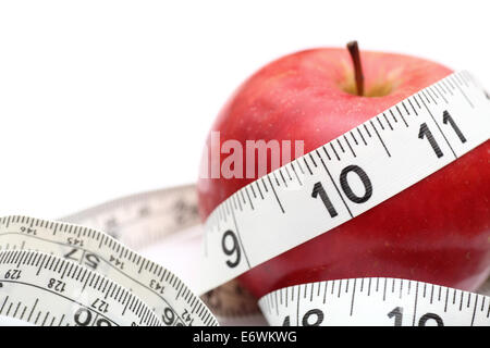 Uno stile di vita sano. Red apple e nastro di misurazione su sfondo bianco. SDOF. Primo piano. Foto Stock