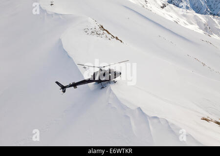 Atterraggio elicottero con gli sciatori e gli snowboarder in neve profonda, sport invernali, Heliskiing, Isola del Sud, Nuova Zelanda Foto Stock