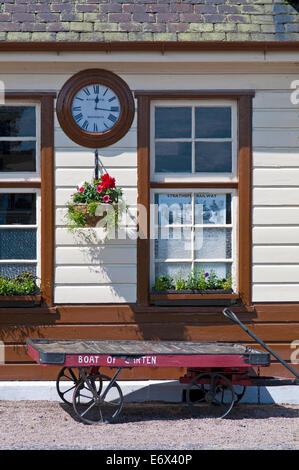 Orologio vintage e carrello bagagli su piattaforma in Boat of Garten vicina, Strathspey Steam Railway, vicino a Aviemore, Cairngorms Foto Stock