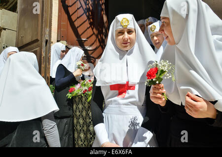 Ritratto di ortodosso orientale suore durante una processione del Venerdì santo nella Città Vecchia di Gerusalemme Foto Stock