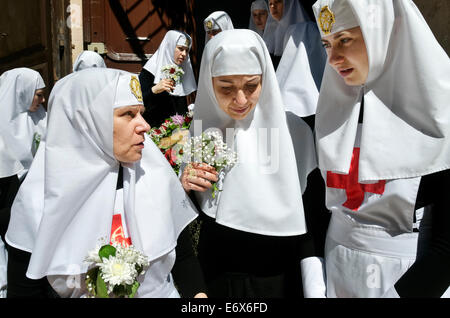 Ritratto di ortodosso orientale suore durante una processione del Venerdì santo nella Città Vecchia di Gerusalemme Foto Stock