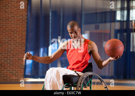 L'uomo con la meningite spinale in carrozzella giocare a basket Foto Stock