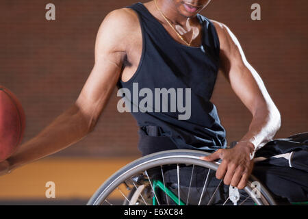 L'uomo con la meningite spinale in carrozzella giocare a basket Foto Stock