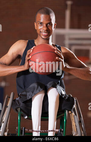 L'uomo con la meningite spinale in carrozzella giocare a basket Foto Stock