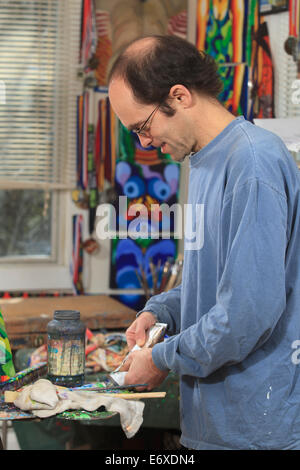 Uomo con Aspergers preparare la vernice nella sua arte studio Foto Stock