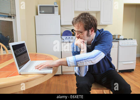 La tecnologia e l'ingegnere programmatore con Aspergers lavorando sul suo computer portatile da casa Foto Stock