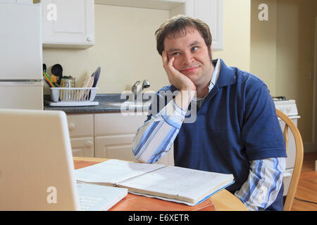 La tecnologia e l'ingegnere programmatore con Aspergers lavorando sul suo computer di casa Foto Stock