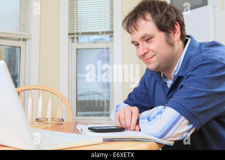 Programmatore con Aspergers lavorando sul suo computer di casa Foto Stock