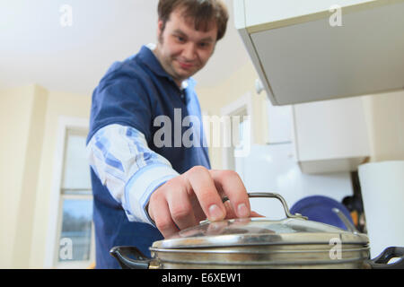 Uomo con Aspergers vivere nella sua casa e cucina Foto Stock