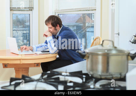 Uomo con Aspergers lavora nella sua casa durante la cottura Foto Stock